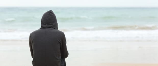 man with addiction looking out to ocean
