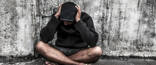 man with addiction with head in hands