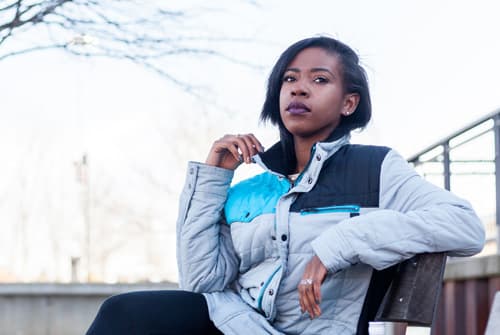 Woman sitting on bench thinking about taking Naltrexone for her addiction