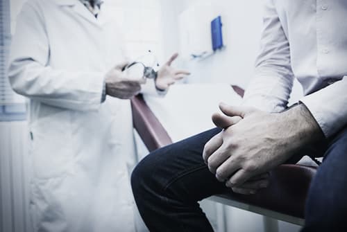 Man being evaluated at doctor's office for drug abuse treatment